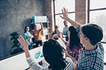 Adults in a classroom raising their hand