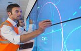 A person pointing at a data screen